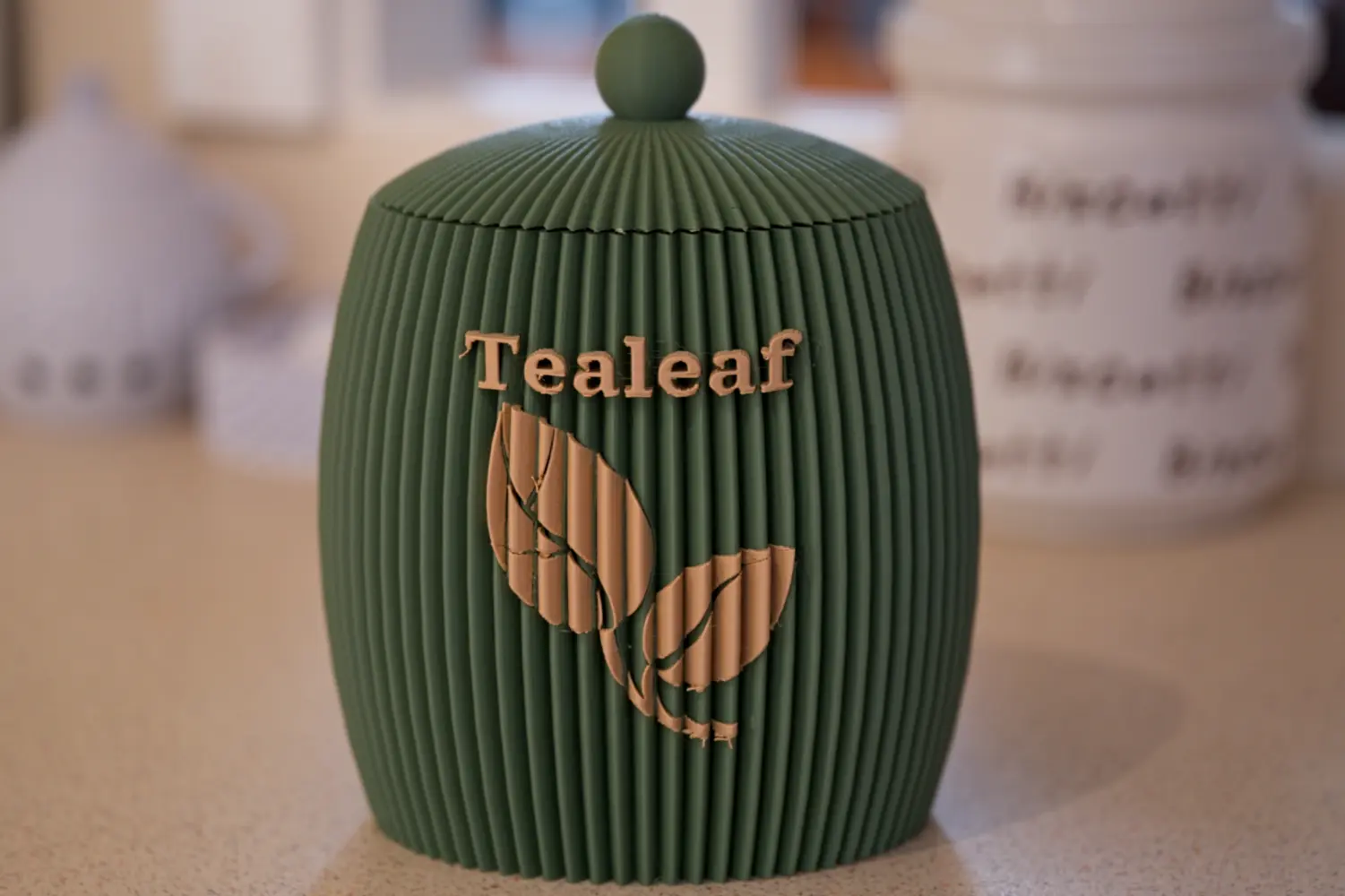 tealeaf-canister-green-front Front view of a green 3D printed tea canister with Tealeaf logo